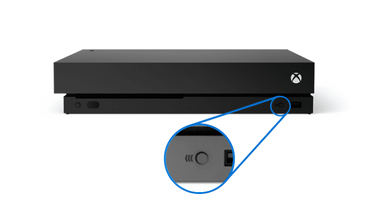 controlador de xbox junto a una consola