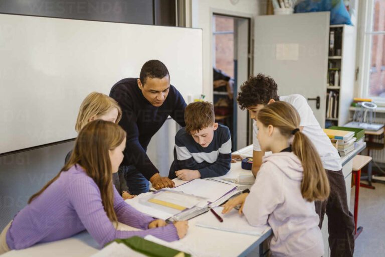 estudiantes en aula con profesor explicando