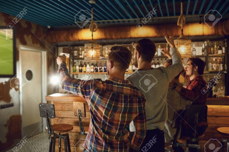 fanaticos viendo futbol en un bar