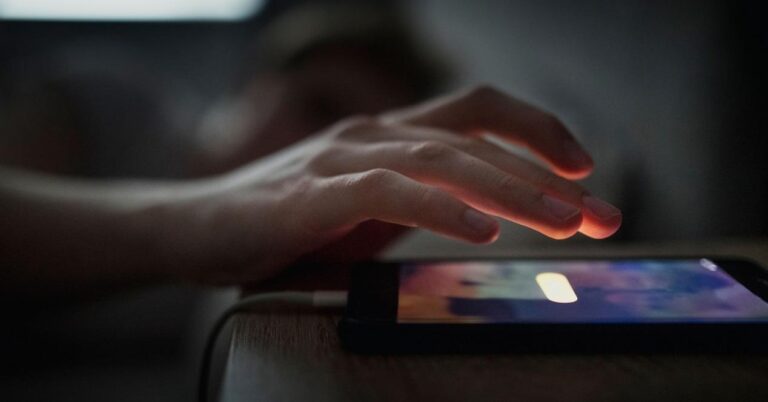 manos reiniciando un celular en la mesa