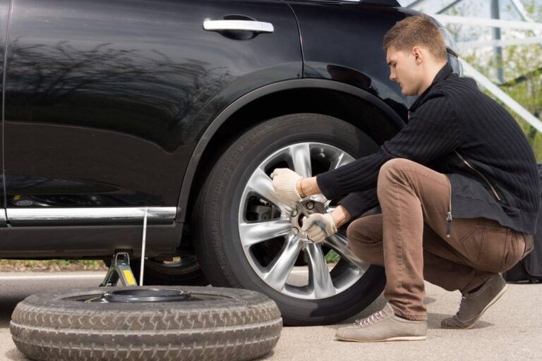 persona cambiando rueda de un automovil