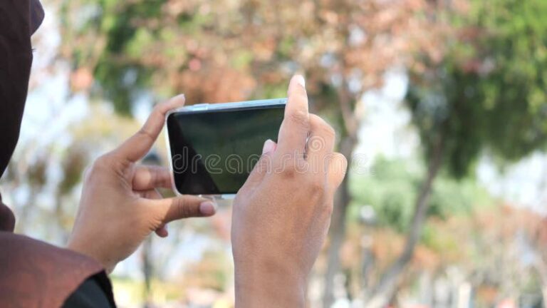 Cómo utilizar la función de texto a voz de Google en tu dispositivo 21 persona utilizando un smartphone en exteriores