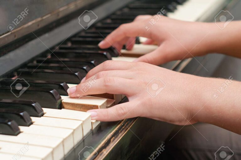 piano con manos tocando teclas